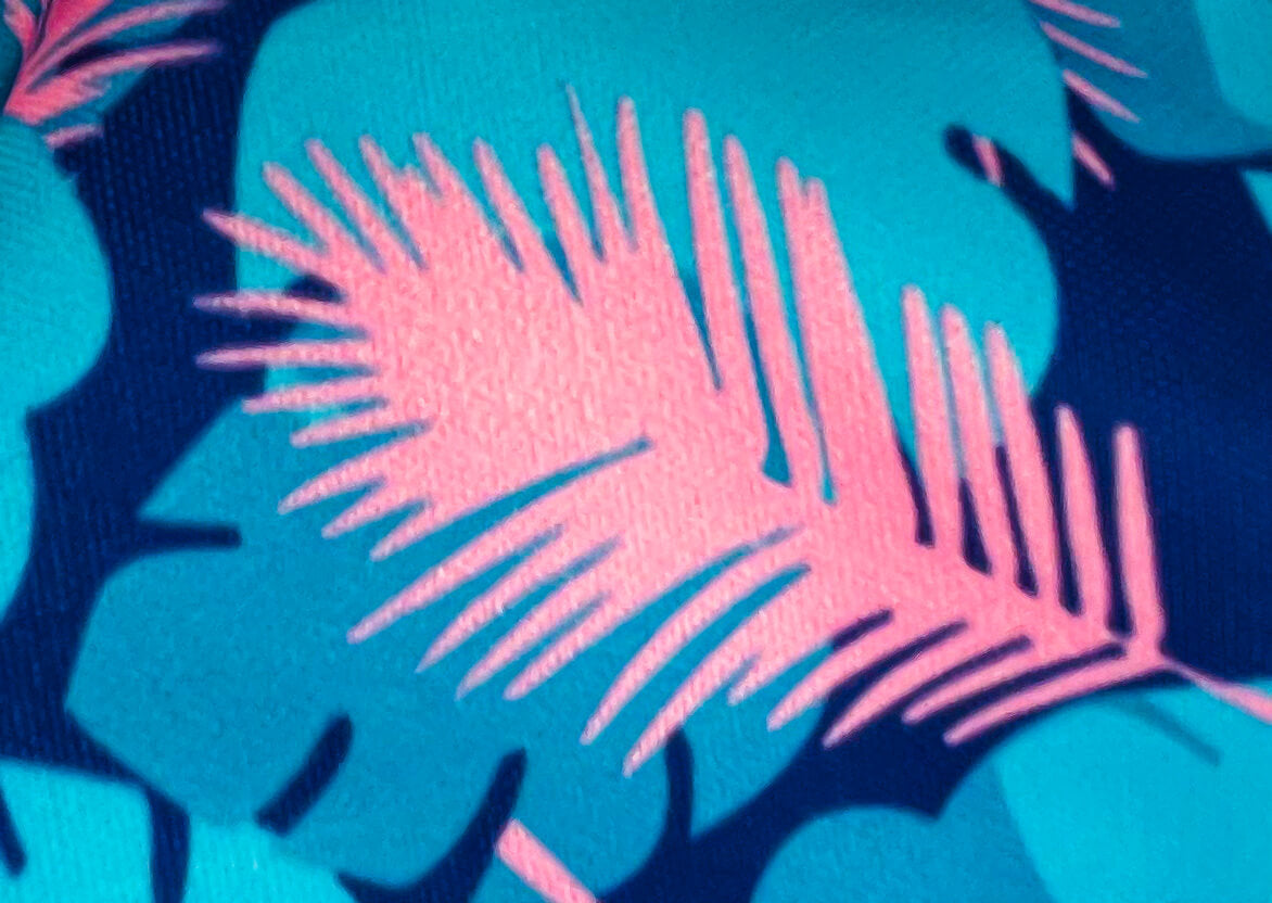 Close up of the digitally printed PUL shell showing the pink feathers, blue leaves and dark blue background.