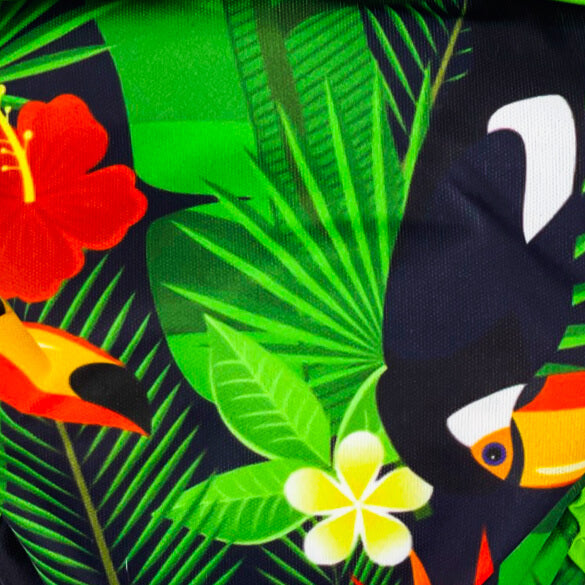 Close up view of the digitally printed PUL shell showing the black background, bright green leaves, red and yellow flowers, and a toucan.